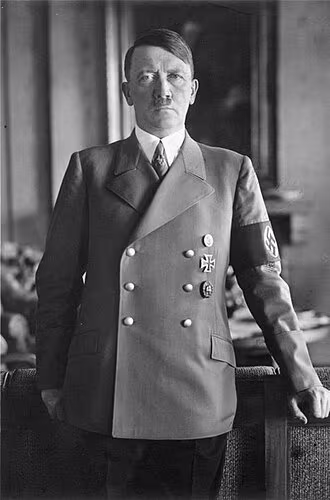 Photographie historique d’Adolf Hitler vers 1938, en uniforme militaire, expression sévère, symbole de la dictature nazie et des crimes commis durant la Seconde Guerre mondiale.